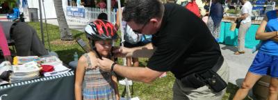 Pole Officer adjusting helmet for young girl